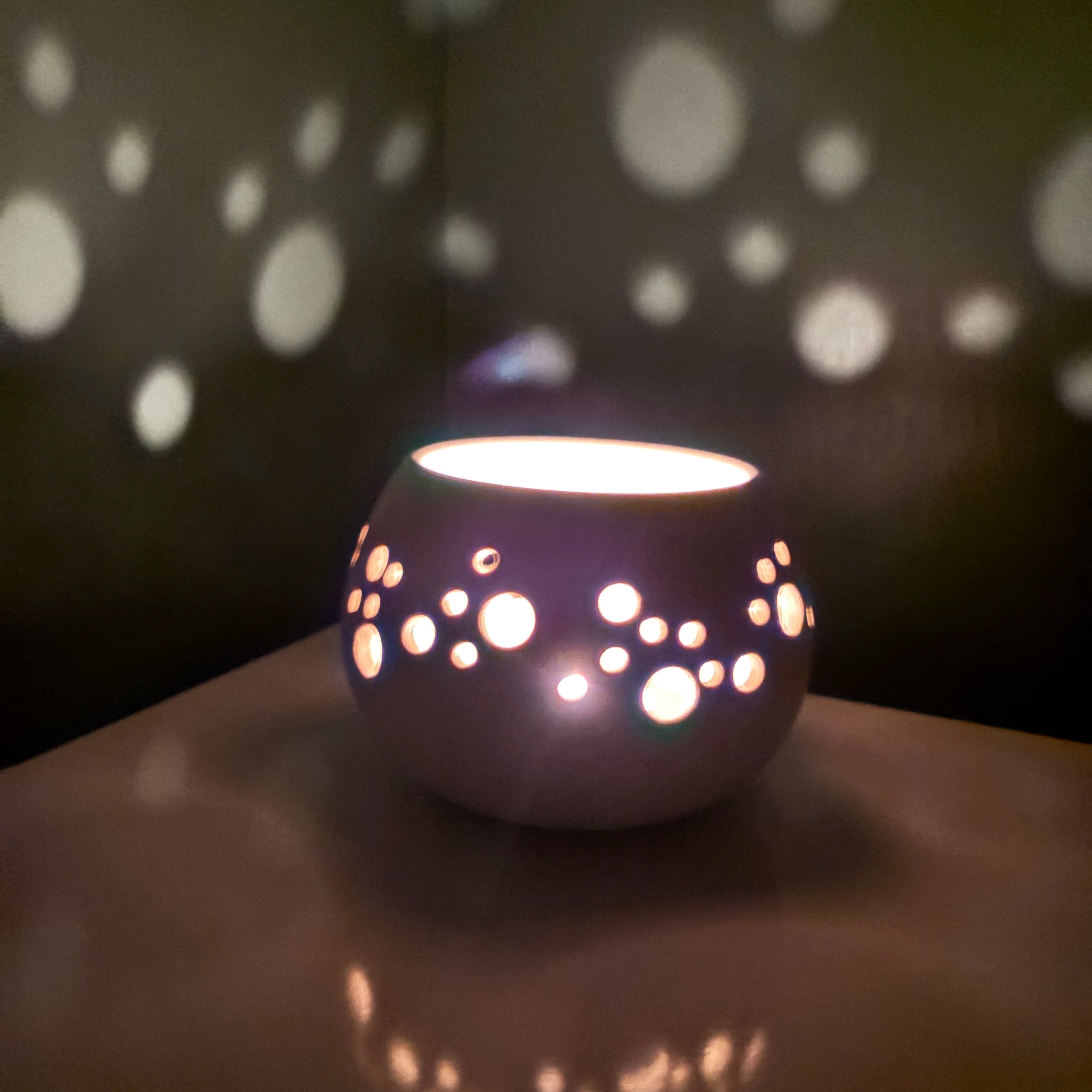 Decorative light fixture casting circular shadows on a wall